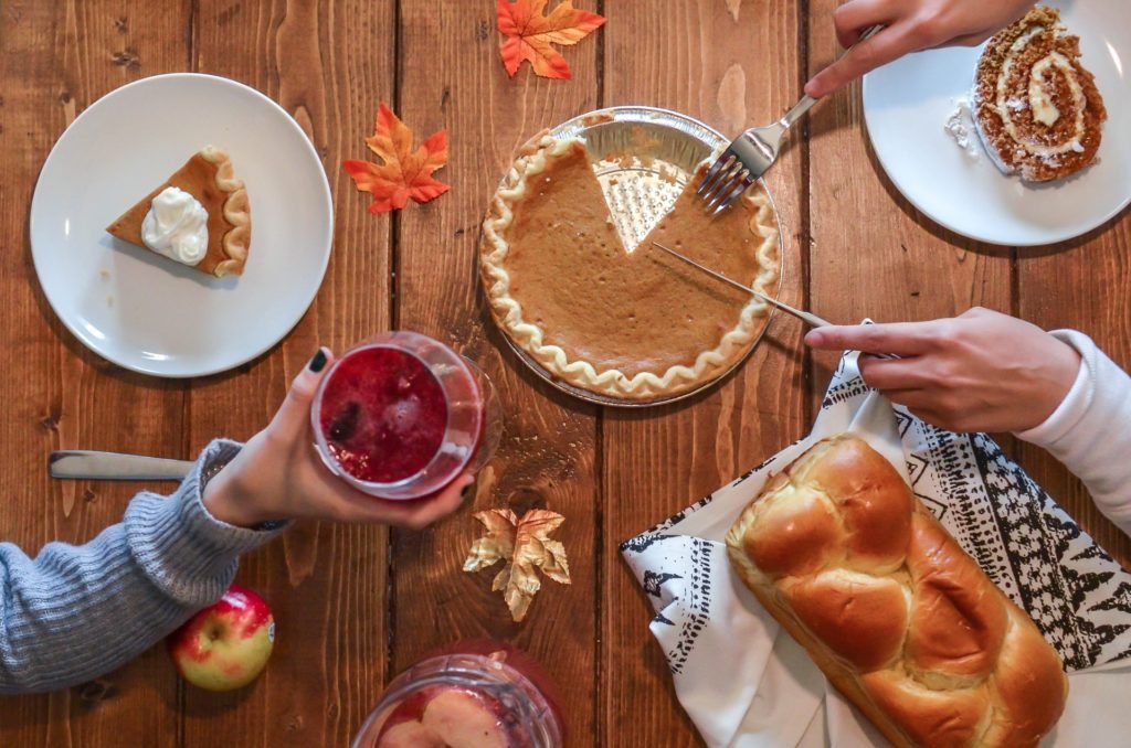 Photo of a table with people enjoying Thanksgiving desserts