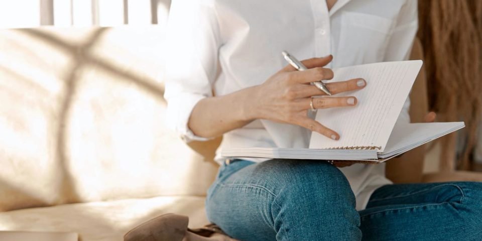 A woman in white who is practicing effective journaling